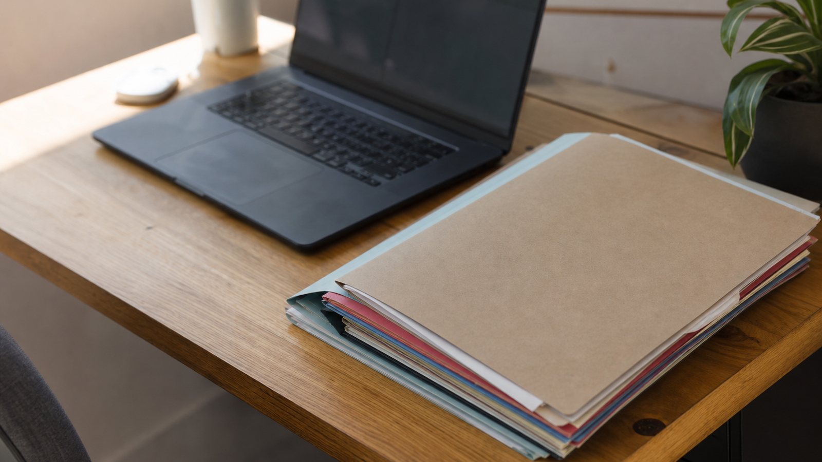 Classeur de fiches patients ouvert à côté d'un ordinateur portable sur le bureau du cabinet